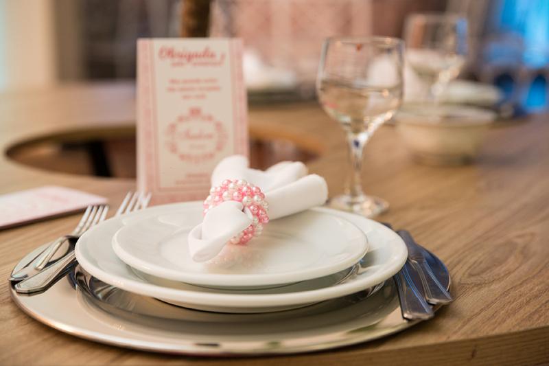 Mesas, pratos, talheres, guardanapos e sousplats de Viena Móveis. Cardápio por Blue Gráfica Express.