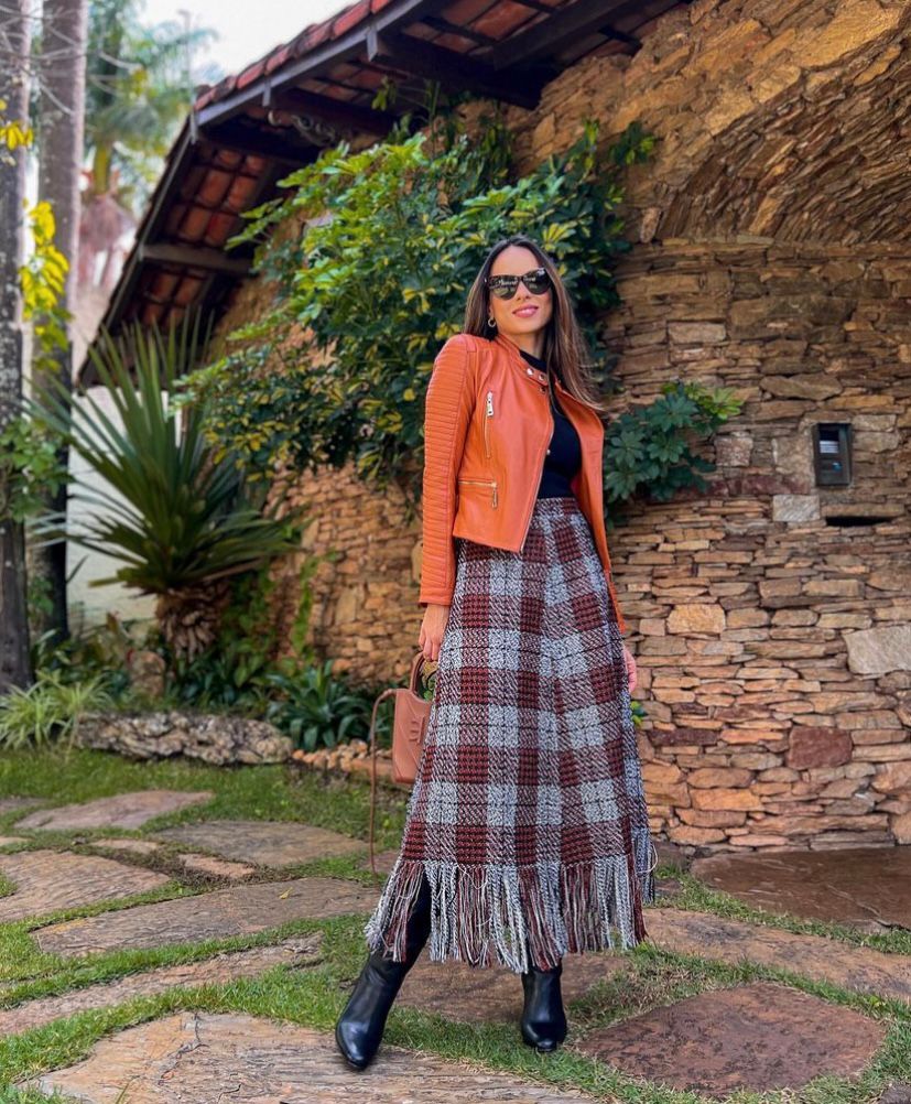 Jaqueta de couro colorida com saia longa xadrez e bota